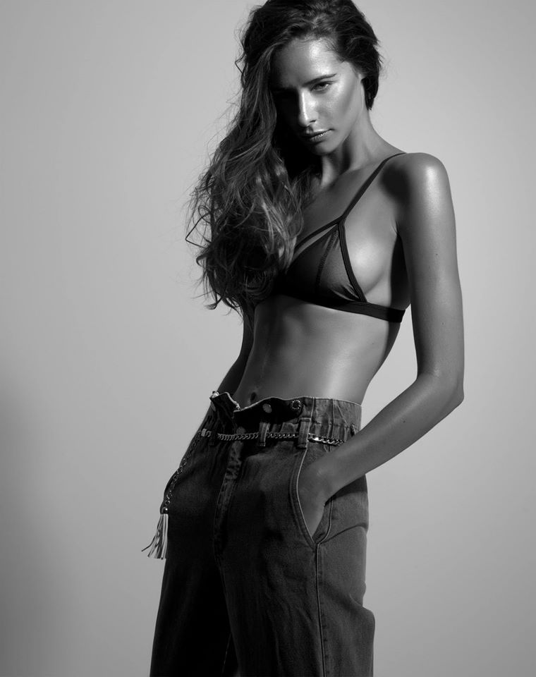 Black and white photo of long haired girl in bra and trousers model shoot