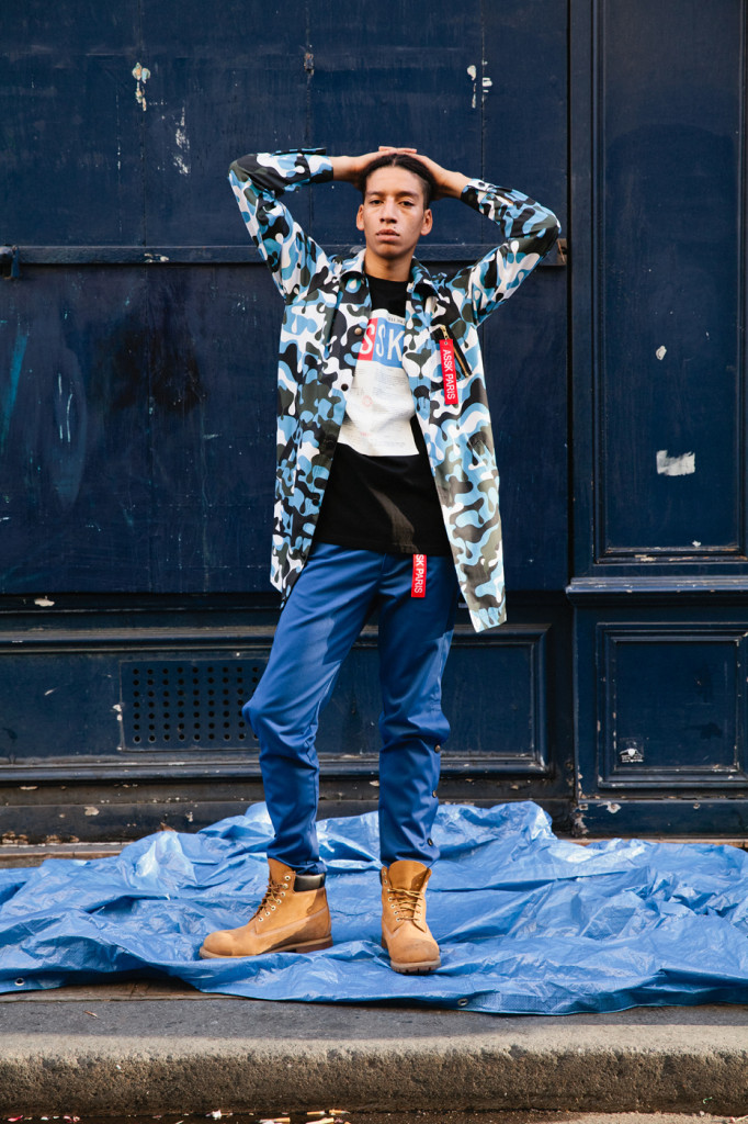 Male Model standing in front of black doors in July 2016 in Paris.