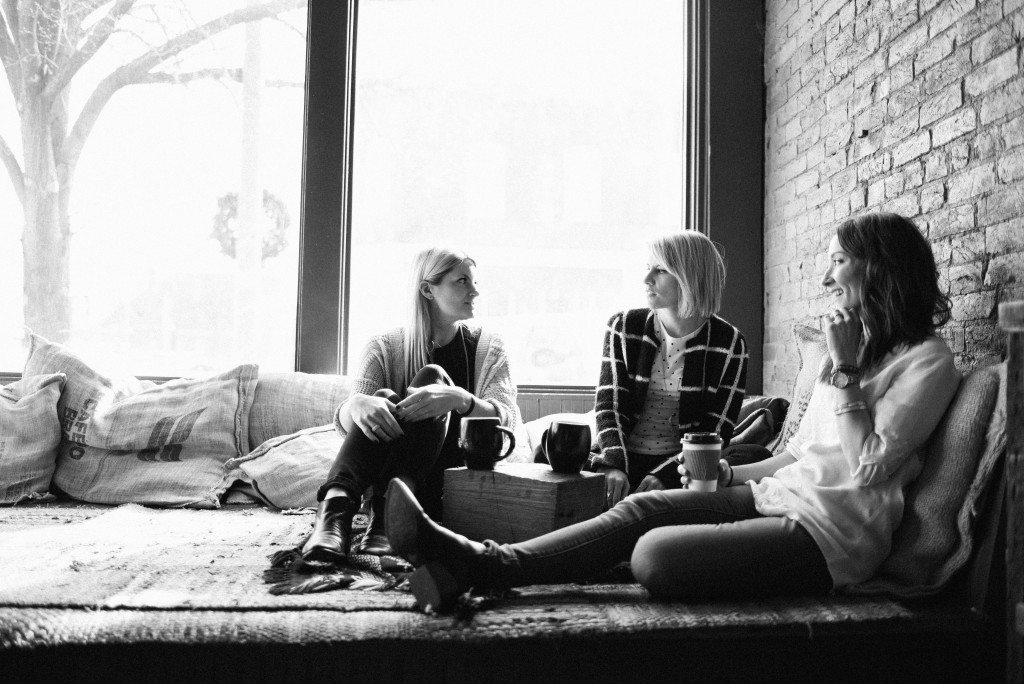 Michelle Houghton and her Instagram friends sitting around talking in a large room with a big open window on a cloudy day.