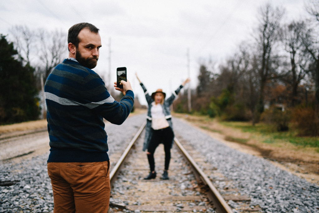 Jenn Fortner and Zac Fortner standing on train tracks for an Instagram pic