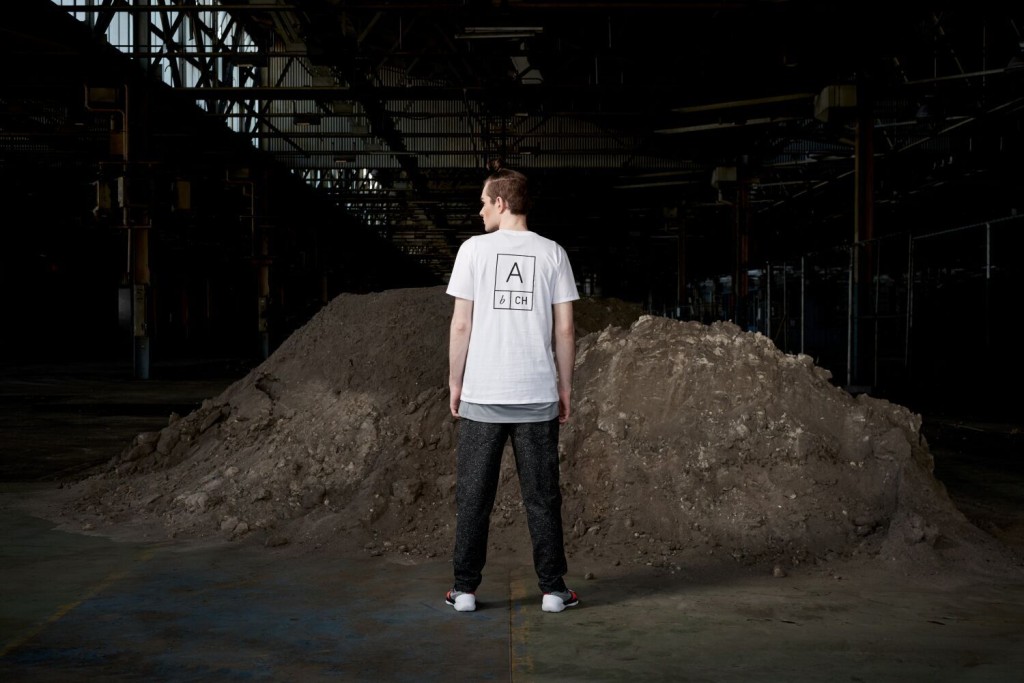 Model standing in an urban setting under a bridge dressed in the sports-luxe wear and technical fabric inspired by pop and internet culture, and elemental street styling.