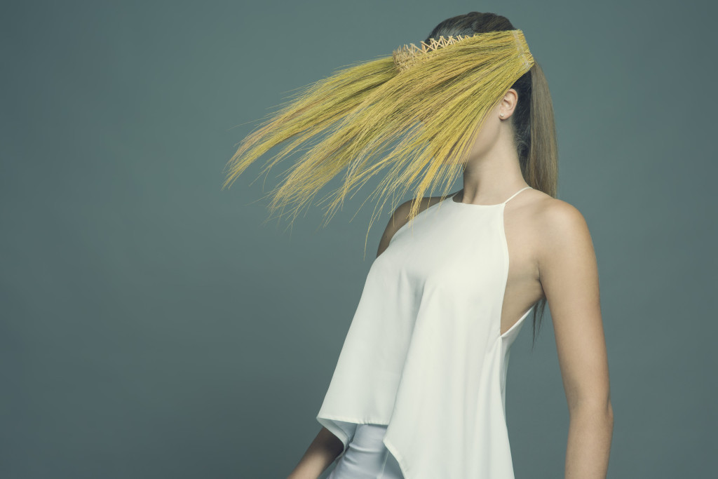 Model standing in a studio wearing the millinery work of Andrew Cannon, a Canberra milliner know as Andrew James Millinery. 