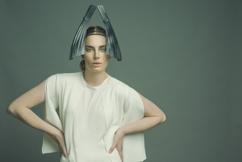 Model standing in a studio wearing the millinery work of Andrew Cannon, a Canberra milliner know as Andrew James Millinery. 