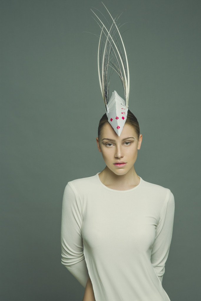 Model standing in a studio wearing the millinery work of Andrew Cannon, a Canberra milliner know as Andrew James Millinery. 