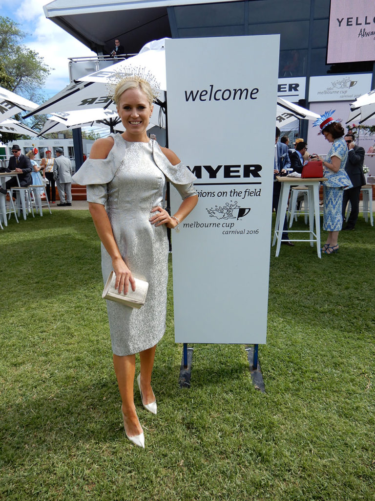 Alice Bright standing in front of the Myer, Fashions on the Field in a silver dress.