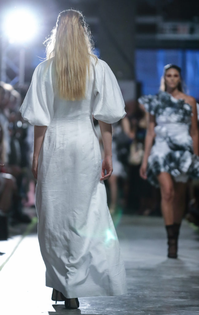 Model on the runway wearing a white ruffled design by Ruth Read from Raffles College of Design Graduate Runway 2016.