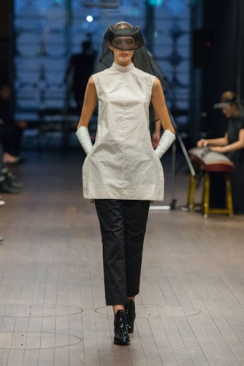 Model walking down the catwalk at the Lui Hon Runway show in Melbourne in white dress/top and black pants