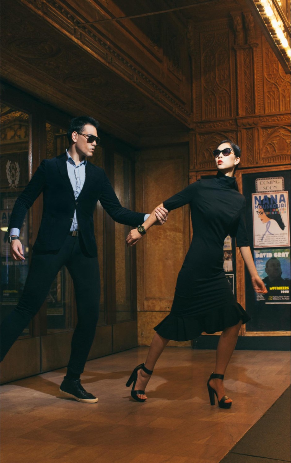 A male and female model walking through the State theatre in elegant clothing