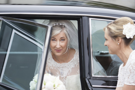 Bride stepping out of the vintage Daimler at the church.